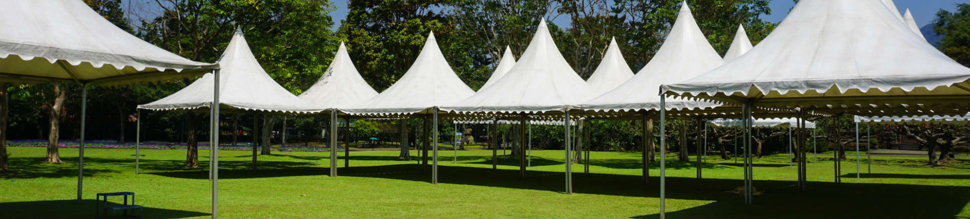 white tents on manicured lawn in garden